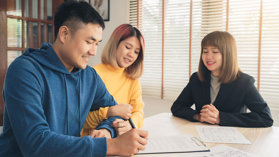 Couple signing a form of an investment product being offered by an investment specialist.