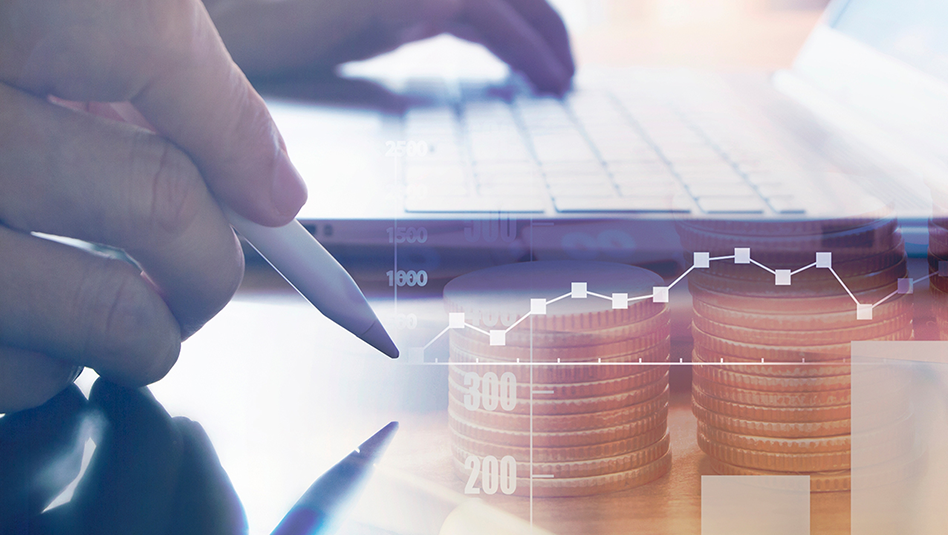 Two hands working, with the left hand on the keyboard of a laptop computer and the right hand holding a pen. On the foreground there is silhouette image of stacked coins and a line graph.