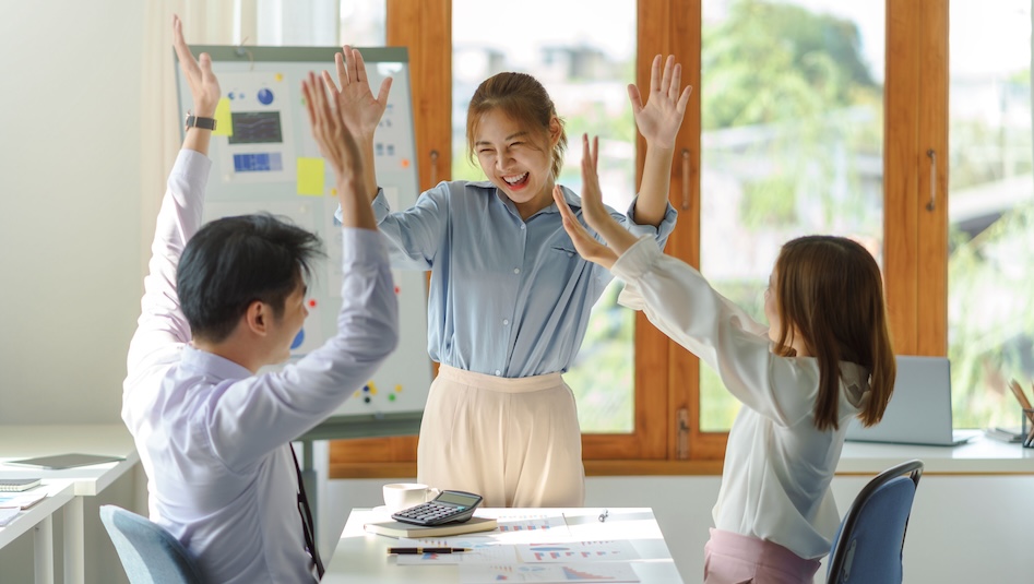 Group young Asian business people with the creative successful excited raised hands rejoicing.