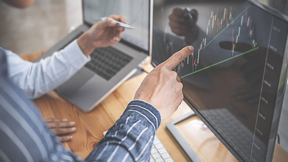 A person pointing to a graph on a computer scree